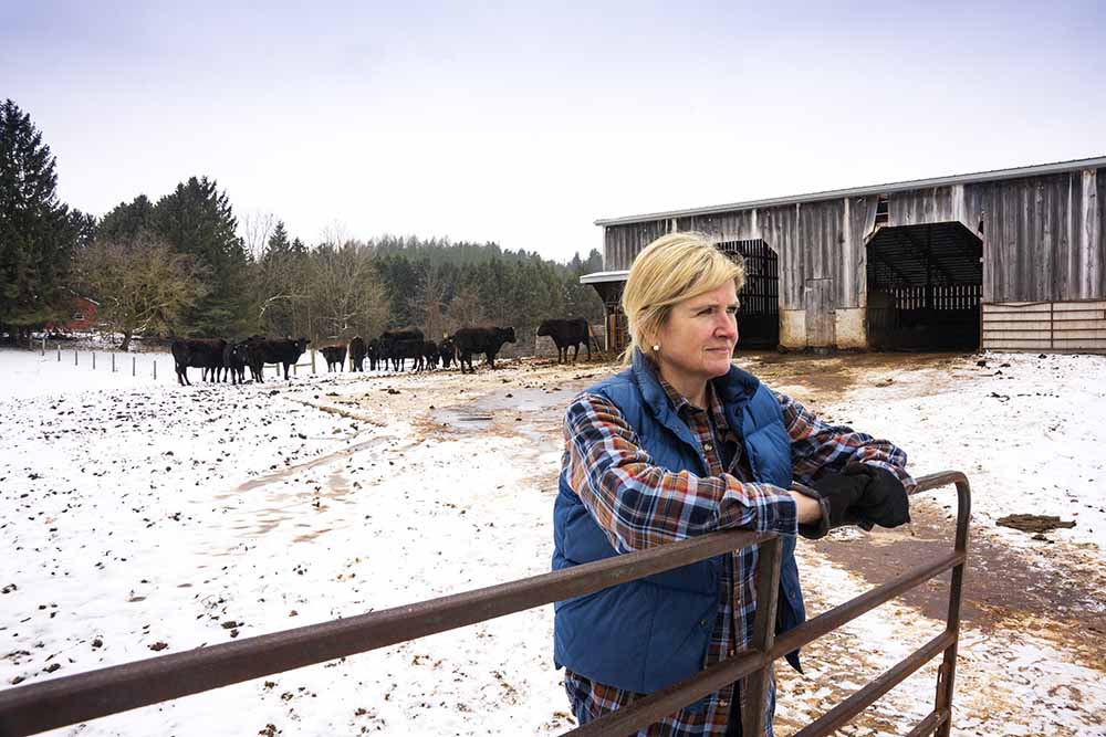 Female farmer leaning on a gate