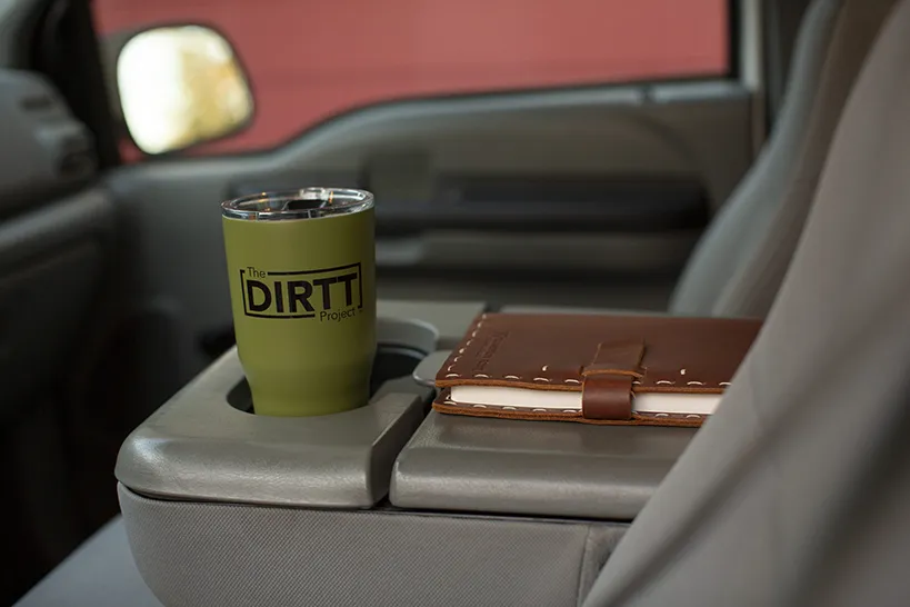 book and mug in truck A DIRTT mug and notebook on the armrest in a truck